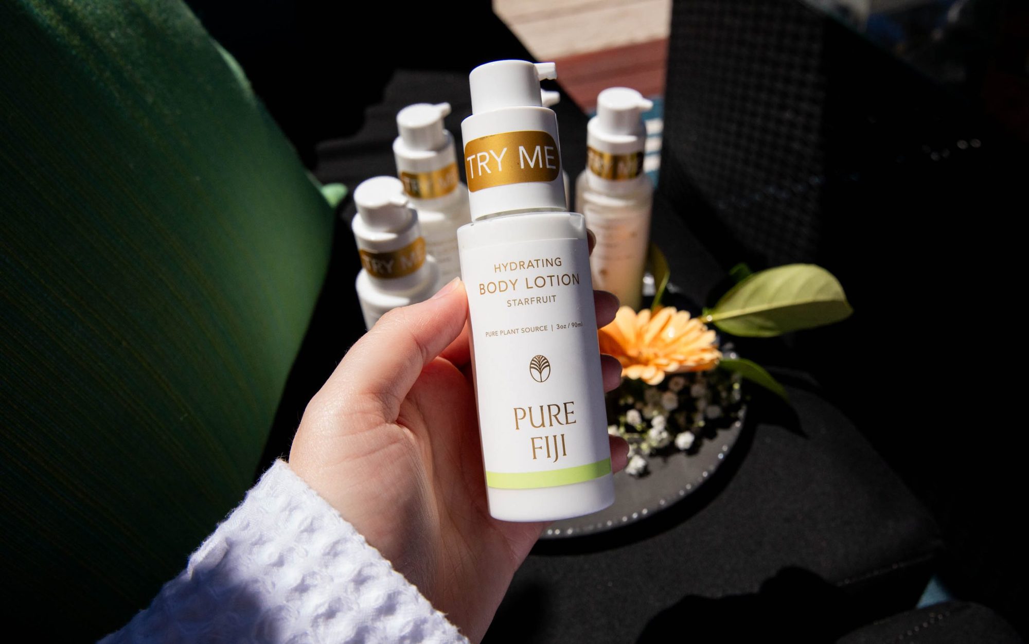 Guest holding a bottle of Pure Fiji body lotion