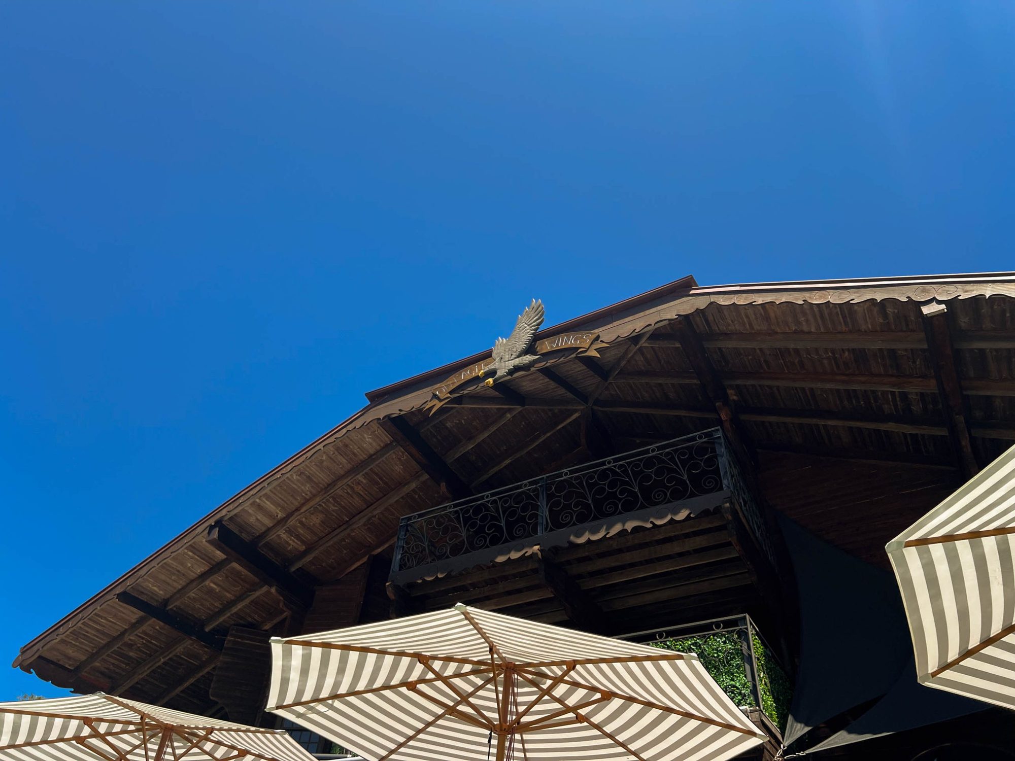 The chalet roofline and eagle sculpture against blue sky
