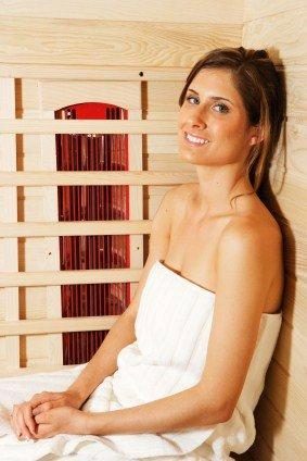 Guest wrapped in a towel seated in an infrared sauna
